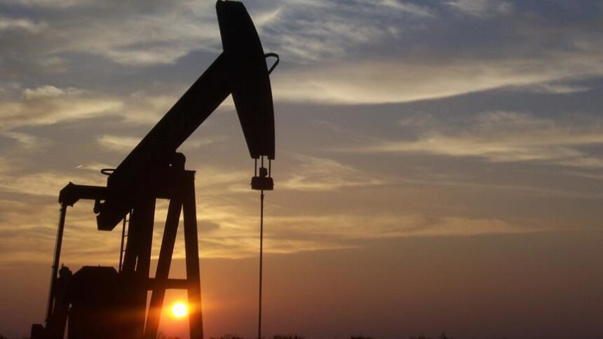 أبراج تكرير النفط تظهر بوضوح في الأفق عند غروب الشمس.