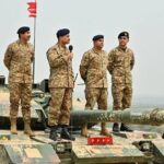 جنود باكستانيون على متن دبابة في منطقة صحراوية.