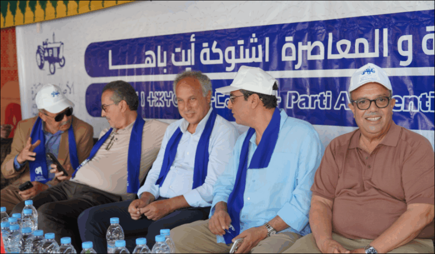أشخاص يجلسون أمام لافتة زرقاء عليها كتابات