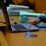 اجتماع عمل على طاولة مع حاسوب محمول ووثائق.