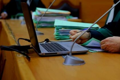 اجتماع عمل على طاولة مع حاسوب محمول ووثائق.