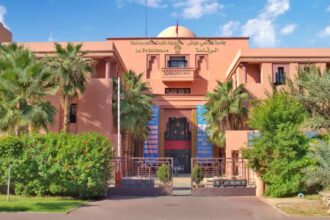 مبنى بلون الخوخ وأشجار نخيل عالية وأعلام أمريكية