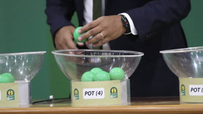 لاعب يسحب قرعة من وعاء زجاجي شفاف.