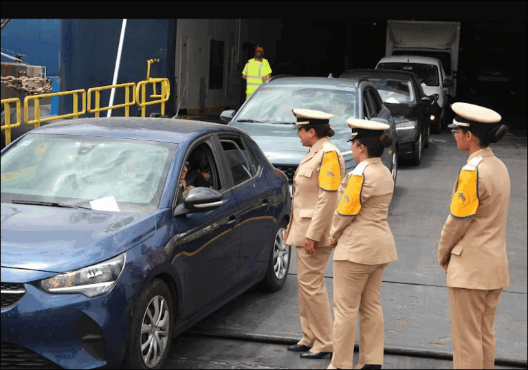 رجال شرطة يرتدون سترات عاكسة يتحدثون مع ركاب سيارة متوقفة.