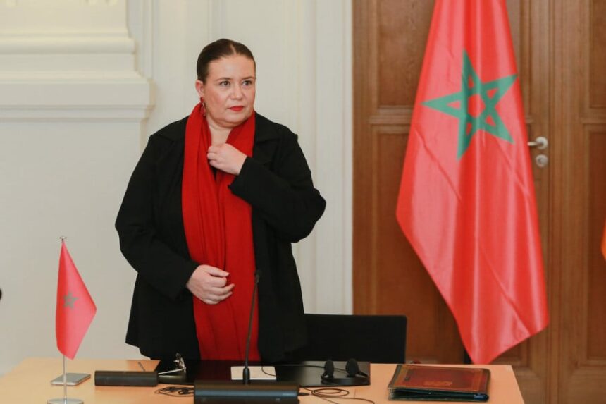 امرأة ترتدي وشاحًا أحمر وتعدل قميصها.