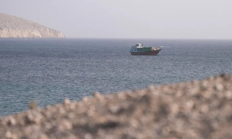 قارب صغير يبحر بالقرب من جزيرة في مضيق هرمز