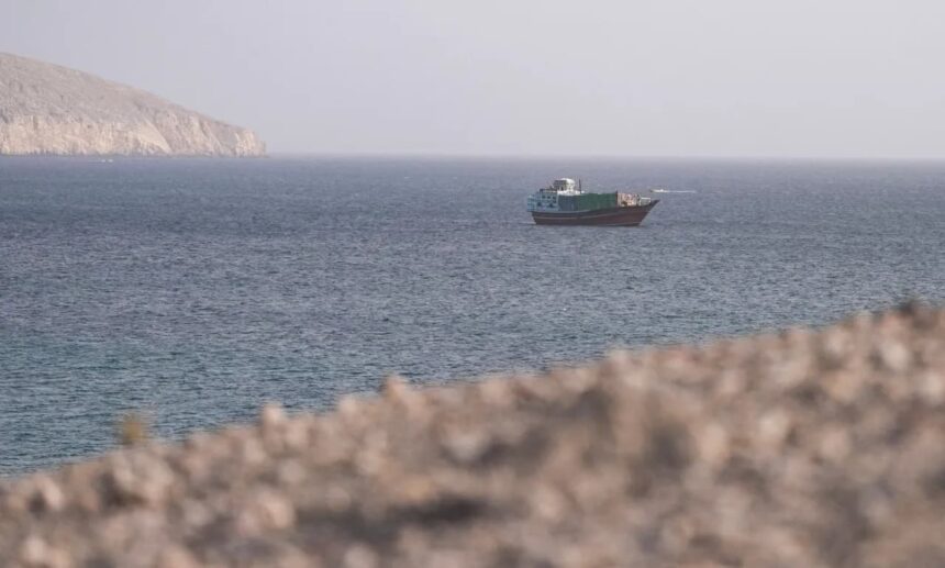 قارب صغير يبحر بالقرب من جزيرة في مضيق هرمز