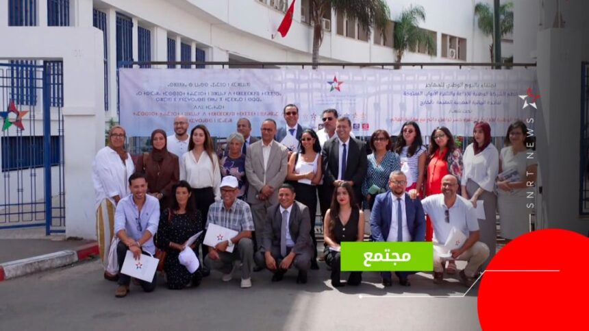 مجموعة من الأشخاص يقفون بجانب لافتة بيضاء.