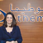 شعار سوطيما مع سيدة ترتدي سترة زرقاء داكنة