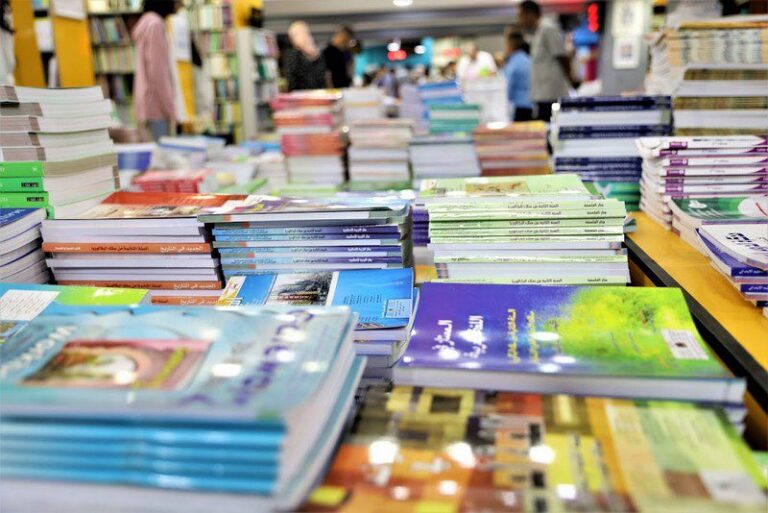 مجموعة من الكتب المدرسية مكدسة فوق بعضها البعض.