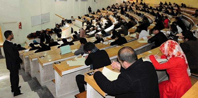 طلاب يجرون امتحانات في قاعة دراسية.