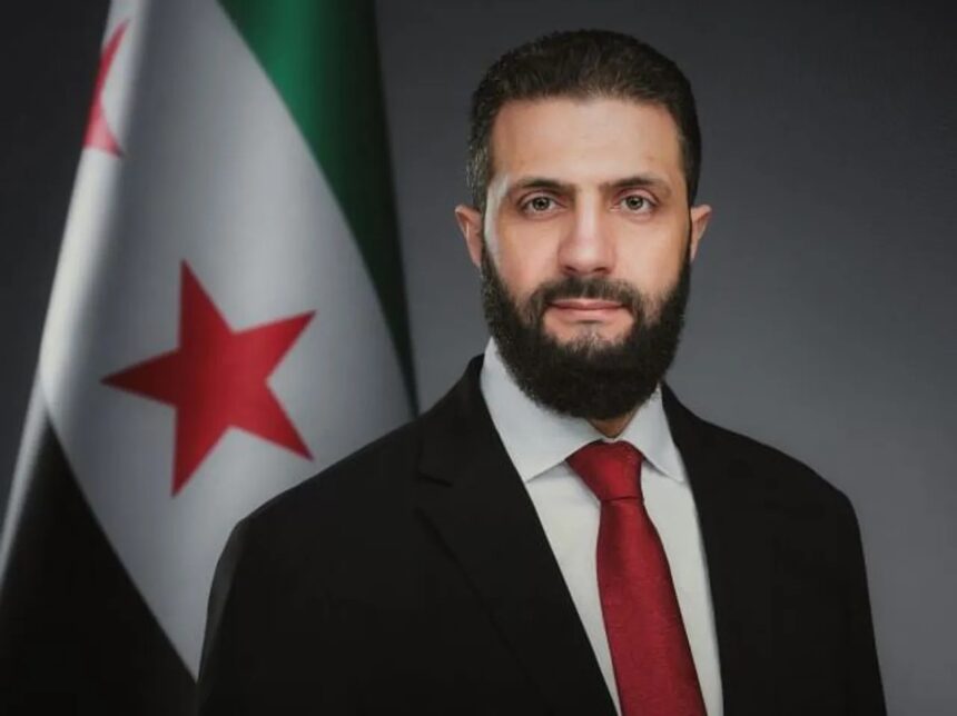 صورة جانبية لرجل بجانب علم سوري.