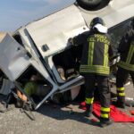 رجال إطفاء ومتطوعون يتجمعون حول شاحنة منقلبة بعد حادث