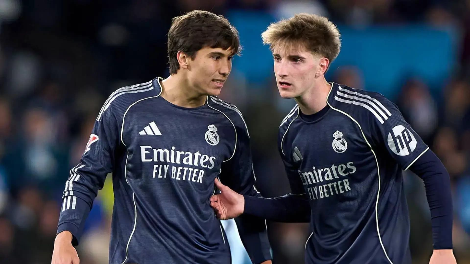 لاعبا كرة قدم بقميص ريال مدريد يبتسمان.
