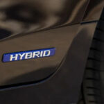 سيارة هجينة بيضاء تظهر عليها كلمة "HYBRID" بوضوح