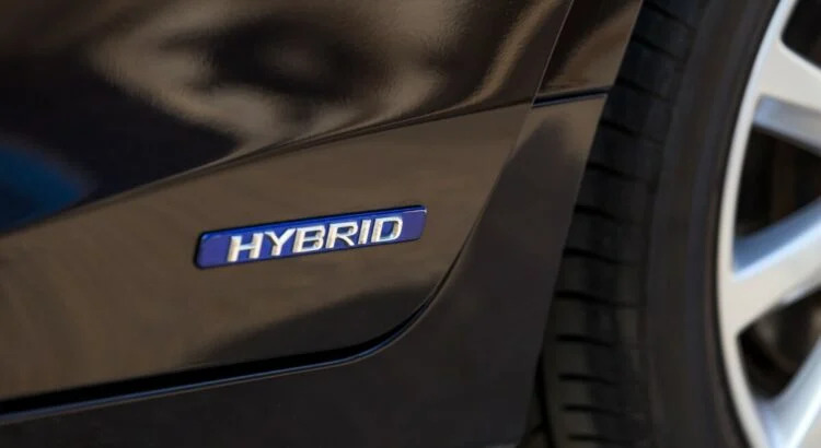 سيارة هجينة بيضاء تظهر عليها كلمة "HYBRID" بوضوح