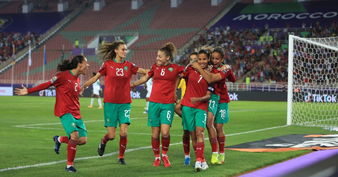 لاعبات كرة قدم يرتدين الزي الأحمر والأخضر في مباراة