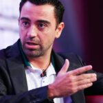 تشافي هيرنانديز يجلس على كرسي وذراعه مرفوعة