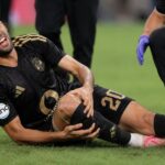 يوسف بلعمري لاعب الأهلي يرتدي قميص أسود وذهبي داخل الملعب