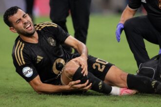 يوسف بلعمري لاعب الأهلي يرتدي قميص أسود وذهبي داخل الملعب