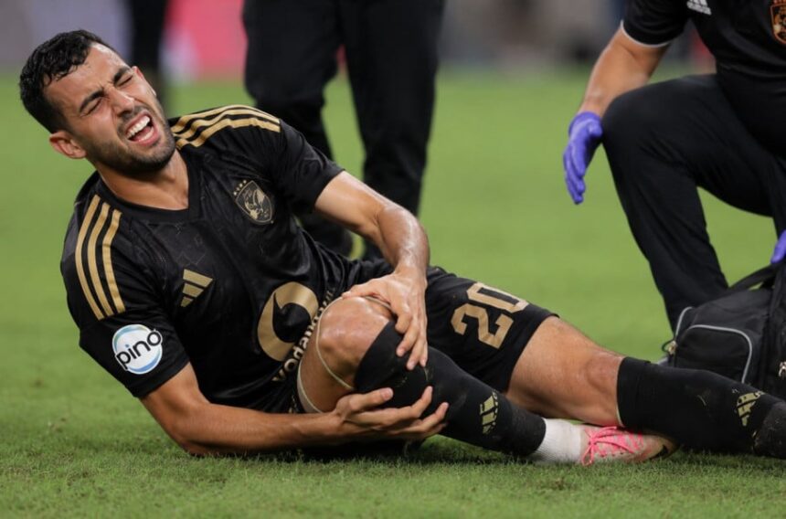 يوسف بلعمري لاعب الأهلي يرتدي قميص أسود وذهبي داخل الملعب