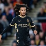 لاعب كرة قدم يرتدي قميص مانشستر سيتي ويحمل شعار الاتحاد