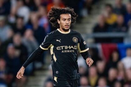 لاعب كرة قدم يرتدي قميص مانشستر سيتي ويحمل شعار الاتحاد