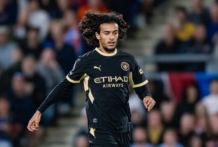لاعب كرة قدم يرتدي قميص مانشستر سيتي ويحمل شعار الاتحاد