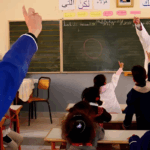 معلم يشرح على سبورة لتلاميذ في الفصل