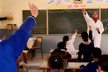 معلم يشرح على سبورة لتلاميذ في الفصل
