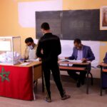 شخص يتحدث أمام مجموعة من الأشخاص الجالسين في قاعة