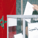 يد تضع ورقة اقتراع في صندوق شفاف خلال انتخابات.