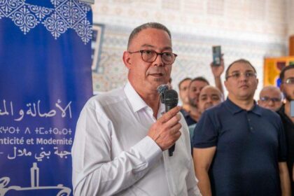 فوزي لقجع يتحدث إلى الجمهور بحماس.