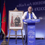 فوزي لقجع يتحدث من منصة الخطابة في تجمع حزبي.