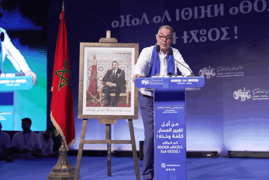 فوزي لقجع يتحدث من منصة الخطابة في تجمع حزبي.