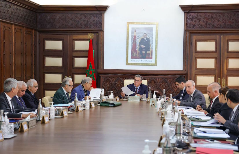 رجال يجلسون حول طاولة اجتماع طويلة في مجلس الحكومة