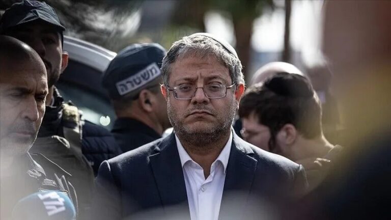 إيتمار بن غفير يرتدي قبعة ويشاهد شيئاً خارج الإطار