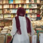 شخص يتفحص رفوف الكتب في معرض