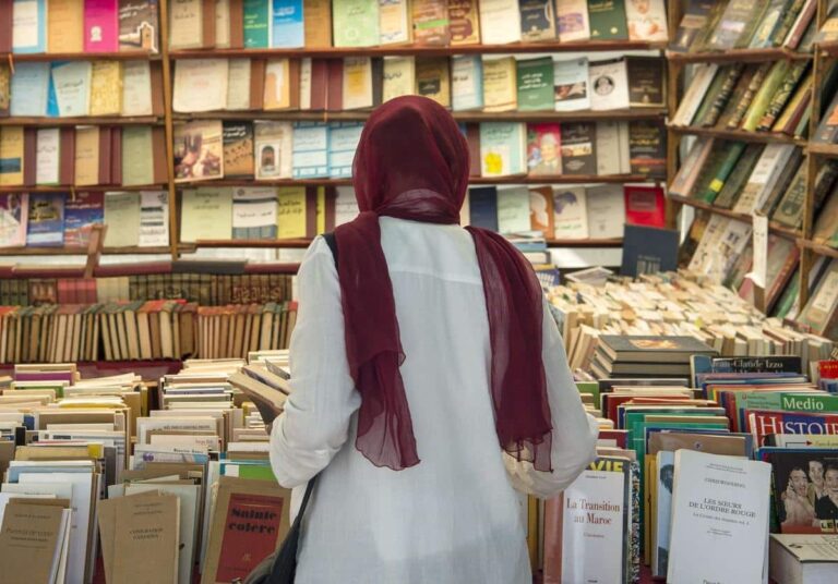 شخص يتفحص رفوف الكتب في معرض