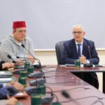 رجل يجلس في مكتب أمامه ميكروفون