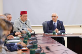 رجل يجلس في مكتب أمامه ميكروفون