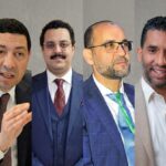 أربعة رجال يرتدون بدلات رسمية ويتحدثون