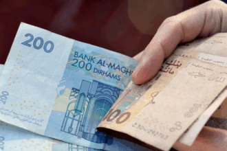 أوراق نقدية مغربية من فئتي 100 و 200 درهم في يد شخص