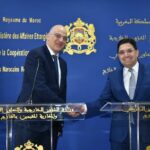 وزيران يتصافحان أمام منصة في لقاء رسمي