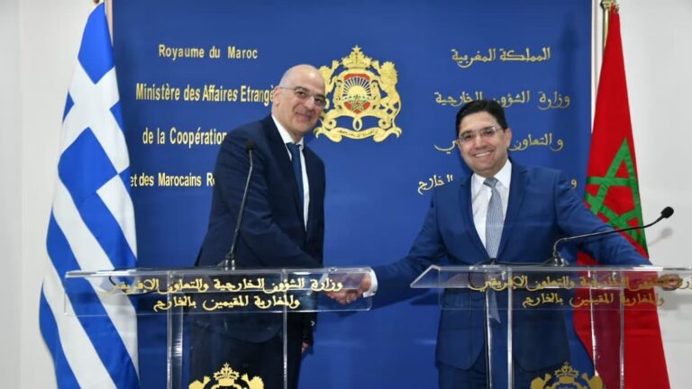 وزيران يتصافحان أمام منصة في لقاء رسمي