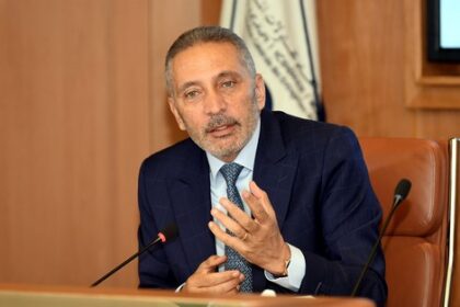 مولاي حفيظ العلمي في مكتبه، يرتدي بدلة داكنة.