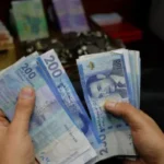 شخص يحمل مجموعة من الأوراق النقدية الباكستانية