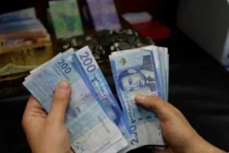 شخص يحمل مجموعة من الأوراق النقدية الباكستانية