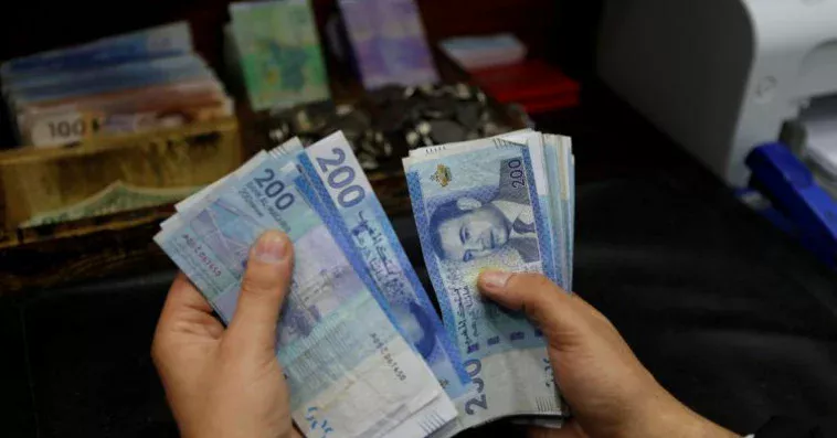 شخص يحمل مجموعة من الأوراق النقدية الباكستانية