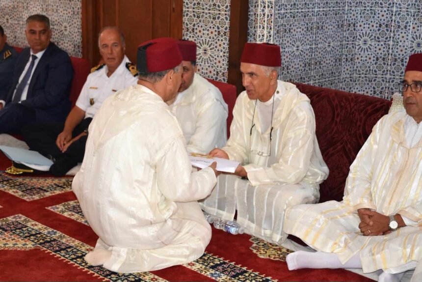 رجال بلباس تقليدي أبيض يجلسون ويؤدون مهامهم.